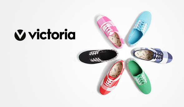 Cinco pares de zapatos coloridos de Victoria Footwear están dispuestos en círculo sobre un fondo blanco. Los zapatos vienen en colores: negro, cuadros rojos y blancos, cuadros rosas y blancos, cuadros azules y blancos y verdes. El logotipo de la marca "Victoria" se muestra en la esquina superior izquierda.