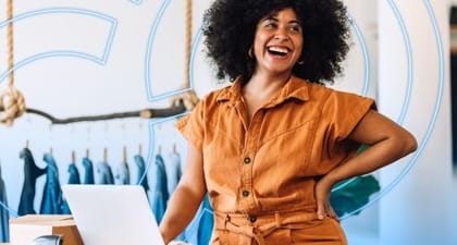 Fashion retailer in stylish workspace using laptop