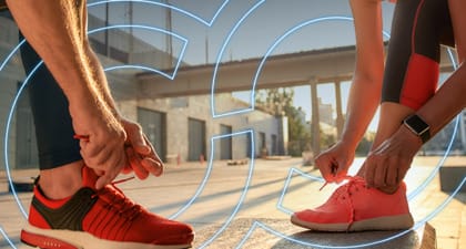 2 people tying their bright colored running shoes