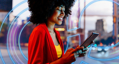 Modern businesswoman smiling while connected on digital tablet outside