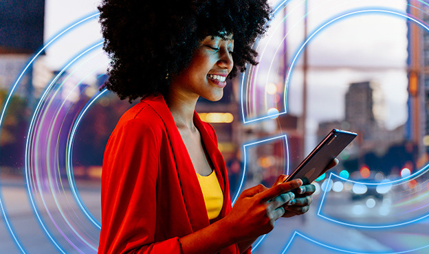 Modern businesswoman smiling while connected on digital tablet outside