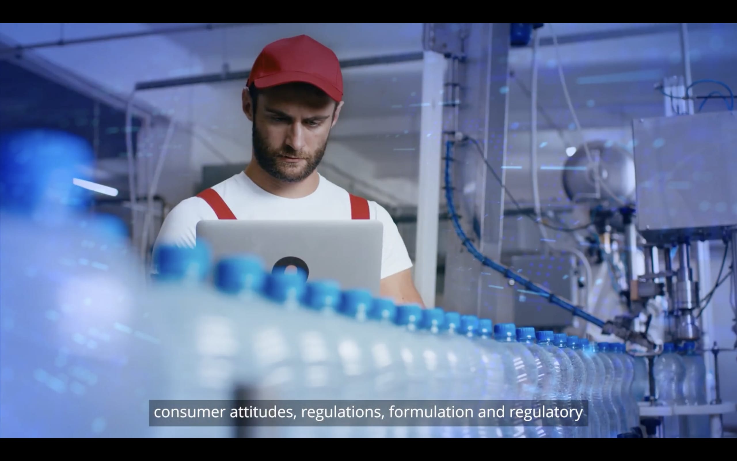 Ein Fabrikarbeiter mit roter Mütze und weißem Hemd benutzt einen Laptop neben einem Förderband mit Wasserflaschen. Im Hintergrund sind Industrieanlagen zu sehen. Auf dem Bildschirm steht „Verbrauchereinstellungen, Vorschriften, Formulierung und Regulierung“.